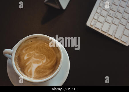 Nahaufnahme der Kaffeetasse auf schwarzer Holztisch Stockfoto