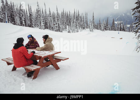 Gruppe von Menschen sitzen zusammen im Skigebiet im winter Stockfoto