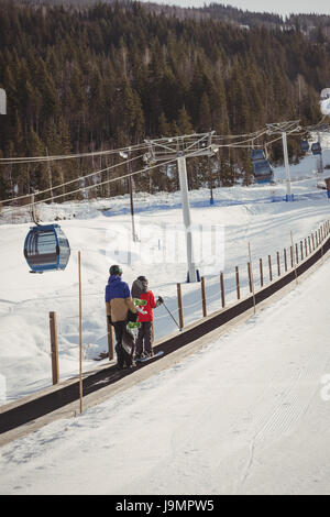 Mutter und Sohn, Skifahren im Winter auf Förderband Stockfoto
