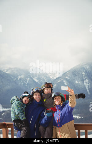 Glückliche Familie nehmen Selfie auf Handy im winter Stockfoto