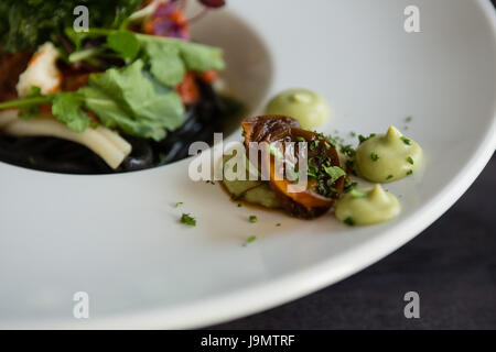 Vogelperspektive Blick auf Salat mit Sauce in Platte im restaurant Stockfoto