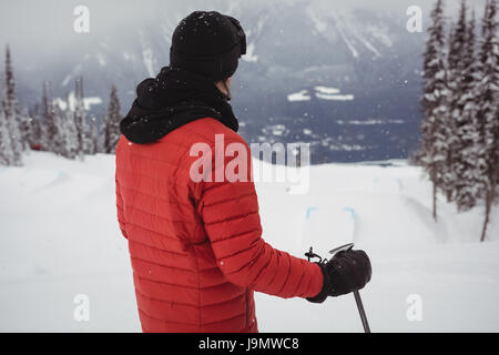 Rückansicht des Skifahrers steht oben auf dem Berg Stockfoto