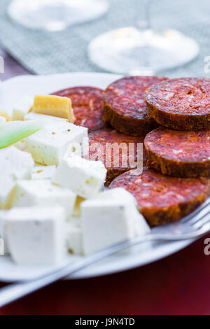 Würzige Wurst und Käse auf einem Teller Stockfoto