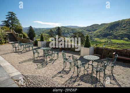 Stühle und Tische auf der Terrasse am Plas Tan y Bwlch Gärten in der Nähe von Maentwrog in Snowdonia, North Wales, UK. Stockfoto