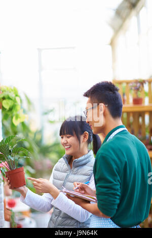 Young Asian männlichen Floristen haben Gespräch mit seinen Kunden im Shop Stockfoto