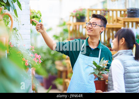 Young Asian männlichen Floristen haben Gespräch mit seinen Kunden im Shop Stockfoto