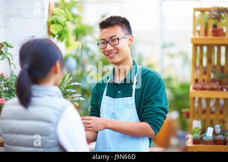 Young Asian männlichen Floristen haben Gespräch mit seinen Kunden im Shop Stockfoto