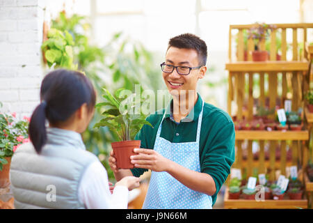 Young Asian männlichen Floristen haben Gespräch mit seinen Kunden im Shop Stockfoto