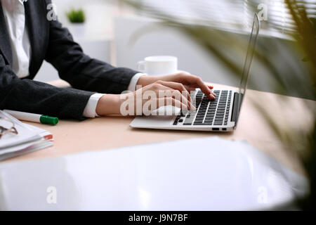 Nahaufnahme des Business Frau Hände Tippen auf Laptop-Computer im weißen farbigen Büro. Stockfoto