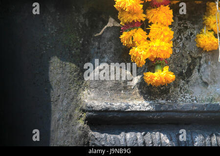 Ein Kranz von Blumen über die Statue des Gottes in abstrakter Form. Rajasthan, Indien Stockfoto