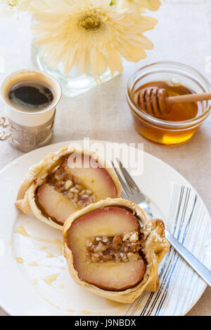 Apfel gefüllt mit Nüssen und gebacken in den Teig-Mantel auf die weiße Platte serviert mit Honig, Nahaufnahme Stockfoto