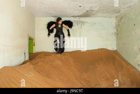 junge Frau ruht in einem Haus, das von Sand überholt worden ist Stockfoto