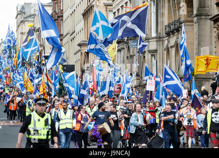 Menschen die Teilnahme am Marsch für Unabhängigkeit Welle Saltires wie sie durch die Innenstadt von Glasgow verarbeiten. Stockfoto