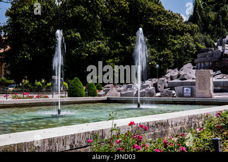 Brunnen schmücken den Park mit Gedenkstein im Hintergrund Stockfoto