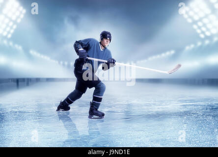 Kanadischer Eishockeyspieler schießen, Stadion am Hintergrund. Schlittschuh laufen Stockfoto