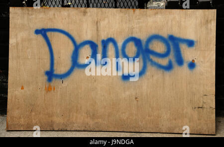 Warnschild mit blauer Tinte auf Holzbrett Stockfoto