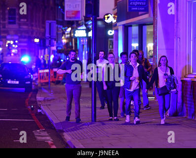 Die Leute laufen die Borough High Street entlang, während die Polizei es mit einem "Major-Vorfall" an der London Bridge zu tun hat. Stockfoto