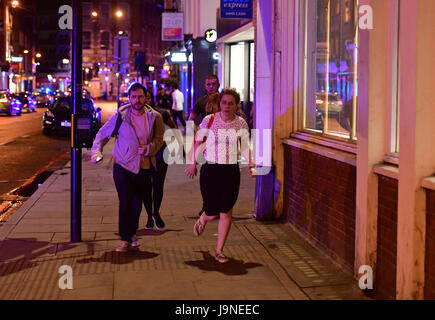 Die Leute laufen die Borough High Street entlang, während die Polizei es mit einem "Major-Vorfall" an der London Bridge zu tun hat. Stockfoto