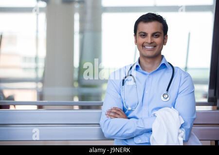 Closeup Portrait freundlich, lächelnd zuversichtlich männlichen Arzt, Gesundheitswesen, professionell mit Stethoskop um Hals, Arme gekreuzt. Stockfoto