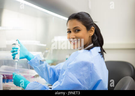 Closeup Portrait, Pipettieren von 50 mL konische Rohr mit blauen flüssige Lösung, Labor experimentieren Wissenschaftler isolierten Labor. Forensik, Stockfoto