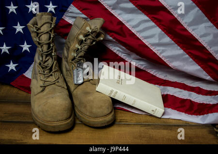 Flagge mit Bibel, Erkennungsmarken, und Kampfstiefel im Gedenken an die gefallenen Stockfoto