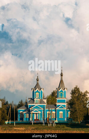 Krasnyy Partizan, Dobrush Bezirk Gomel Region, Weißrussland. Alte hölzerne orthodoxe Kirche der Geburt der Jungfrau Maria bei Sonnenuntergang im Dorf Stockfoto