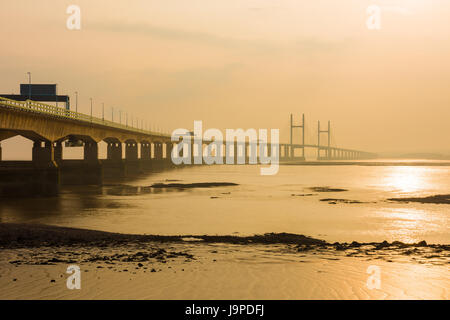 Der Prinz von Wales Brücke (Zweite Severn Crossing) während einer diesigen Sonnenuntergang über den Severn Estuary von Severn Strand, Gloucestershire, England gesehen. Stockfoto