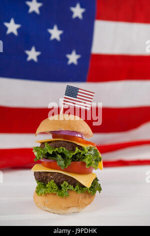 Hamburger mit 4. Juli Thema gegen amerikanische Flagge Stockfoto