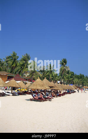 China, Hainan Island, Sanya, Dadonghai Beach Tourist, Asien, Ostasien, Reiseziel, Strand, Sandstrand, Liegestühle, liegen, am Strand liegen, Sonnenschirme, Palmen, Menschen, Urlauber, Urlaub, Erholung, Strandurlaub, im Außenbereich Stockfoto