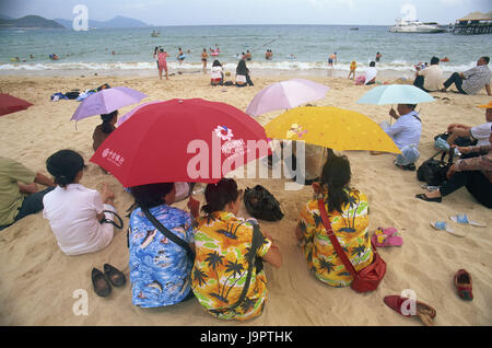 China, Hainan Island, Sanya, Dadonghai Beach, Tourist, Rückansicht, Sonnenschirme, Asien, Ostasien, Reiseziel, Strand, Sandstrand, Sonnenschirme, Sonnenschutz, Person, Urlauber, Urlaub, Ruhe, Strandurlaub, außen, Meer, Meerblick, Badende, gezeichnet, Kleider, Stockfoto