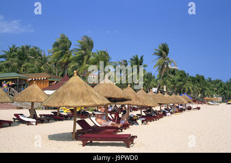 China, Hainan Island, Sanya, Dadonghai Beach Tourist, Asien, Ostasien, Reiseziel, Strand, Sandstrand, Liegestühle, liegen, am Strand liegen, Sonnenschirme, Palmen, Menschen, Urlauber, Urlaub, Erholung, Strandurlaub, im Außenbereich Stockfoto