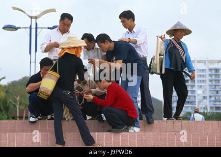 China, Hainan Island, Sanya, Dadonghai Beach, Souvenir-Verkäufer, Tourist, kein Model-Release, Asien, Ostasien, Reiseziel, Person, Urlauber, Touristen, Tourismus, Souvenirs, Verkauf, Straßenhändler, Straßenverkauf, Pflege, Kopfbedeckungen, Interesse, Produkt, Stockfoto