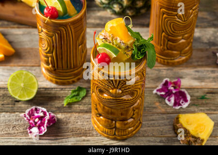 Erfrischende kalte Tiki Drink Cocktails mit Ananas-Kirsche Orange Beilagen Stockfoto