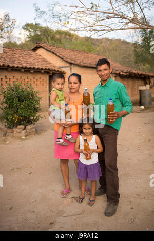 Eine Familie von Honigbiene Keepers halten Flaschen von frisch geernteten Honig in Léon Abteilung, Nicaragua. Stockfoto