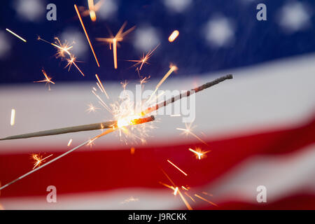 Nahaufnahme von Wunderkerzen brennen gegen amerikanische Flagge Hintergrund Stockfoto