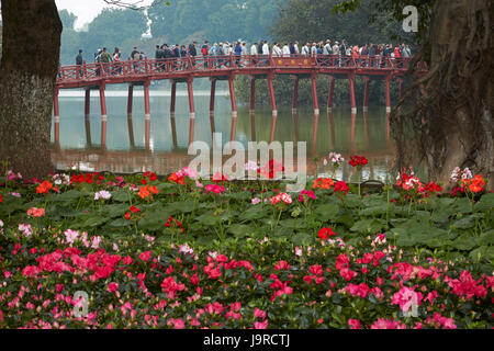 Blumen, Touristen auf die Huc Brücke und Hoan-Kiem-See, Hanoi, Vietnam Stockfoto