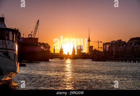 Fluss Spree, Oberbaumbrücke, Fernsehturm - Berlin Skyline der Stadt mit Sonnenuntergang Himmel Stockfoto