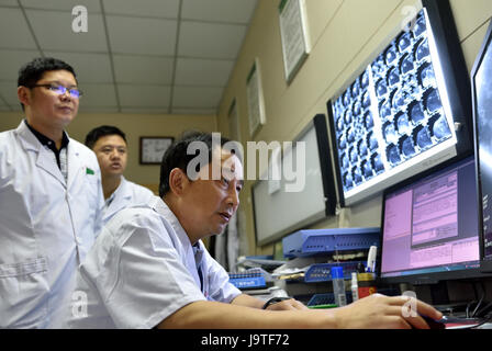 (170603)--YICHANG, 3. Juni 2017 (Xinhua)--Surgeon Mei Changqing (R) Uhren nukleare magnetische Resounance Bilder auf der Menschen Hospital of Zigui County, Hubei Provinz Zentral-China, 24. Mai 2017. Mei Changqing gehört zu denjenigen, die die Wiederaufnahme der College-Aufnahmeprüfung 1977 profitiert. Der Chirurg, als Schriftsetzer in 1976 nach Abitur, sein Schicksal durch Einnahme der College-Aufnahmeprüfung 1977 verändert und wurde von Yichang Medical School eingeschrieben. Seit 30 Jahren in der klinischen Medizin engagiert worden, ist Mei Changqing stolz auf seine Wahl. (Xinhua/Wang Stockfoto