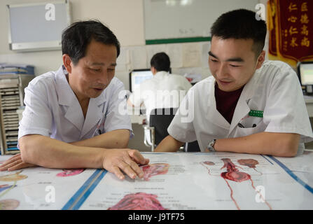 (170603)--YICHANG, 3. Juni 2017 (Xinhua)--Chirurg Mei Changqing (L) Gespräche mit Arzt Liu Gang an das Volk Hospital of Zigui County, Hubei Provinz Zentral-China, 3. Juni 2017. Mei Changqing gehört zu denjenigen, die die Wiederaufnahme der College-Aufnahmeprüfung 1977 profitiert. Der Chirurg, als Schriftsetzer in 1976 nach Abitur, sein Schicksal durch Einnahme der College-Aufnahmeprüfung 1977 verändert und wurde von Yichang Medical School eingeschrieben. Seit 30 Jahren in der klinischen Medizin engagiert worden, ist Mei Changqing stolz auf seine Wahl. (Xinhua/Lei Yong) (Lfj) Stockfoto