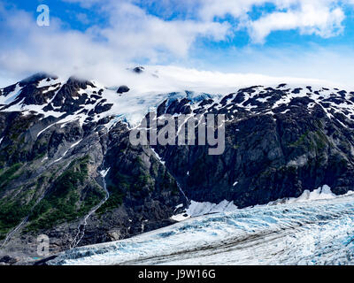 Blick auf Schnee bedeckt Berge gekrönt mit ein Hauch von Wolken hoch über Exit-Gletscher von Exit Glacier Trail in Kenai Fjords Nationalpark, A aus gesehen Stockfoto