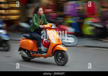 Stilvolle Frau auf orange Roller, Altstadt, Hanoi, Vietnam Stockfoto