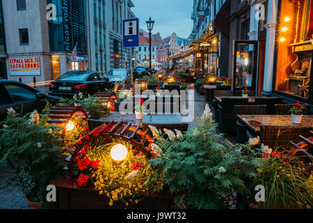 Riga, Lettland - 3. Juli 2016: Freie Tische von A Street Cafe mit dekorativen Beleuchtung am Abend oder Nachtbeleuchtung In der Altstadt In Kungu Straße Stockfoto