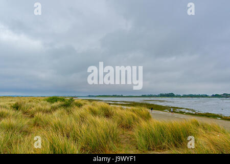 Salzwiesen umgeben von einem großen See. Menschen zu Fuß auf einem Pfad rund um den See. Stockfoto