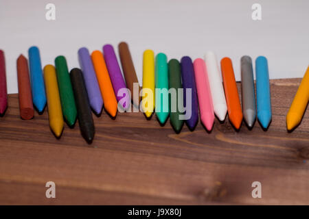 Bunte Stifte mit einem leeren weißen Blatt Papier auf einem hölzernen Hintergrund. Stockfoto