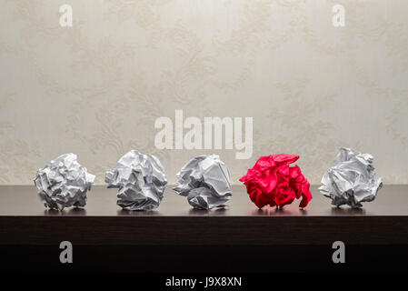 Fünf zerknittertes Papierkugeln auf einem dunklen Holztisch. Forschung oder kreativen Prozesskonzept Stockfoto