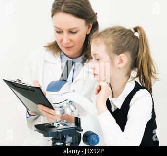 Frau und kleine Mädchen mit Mikroskop im Labor. Stockfoto