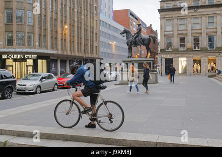 Deliveroo Uber Auslieferungsfahrer Biker Radfahrer auf der Straße nach Glasgow im Hinblick auf die Kegel Kopf Herzog von Wellington statue Stockfoto
