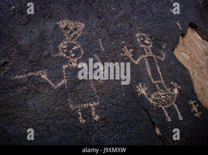 Pueblo zeremonielle Figuren/Anthropomorphs geschnitzt auf Basaltfelsen am Boca Negra Canyon, Petroglyph National Monument, Albuquerque, New Mexico, USA. Stockfoto