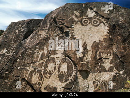 Pueblo zeremonielle Figuren geschnitzt auf Comanche Lücke vulkanischen Deich, Galisteo Basin, New Mexico, USA. Rio Grande Stil Schild Krieger, C AD1325-AD1680. Stockfoto