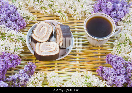 Designerhintergrund aus den Zweigen der Weide, Blumen Flieder, Tasse Kaffee und Meat loaf Stockfoto